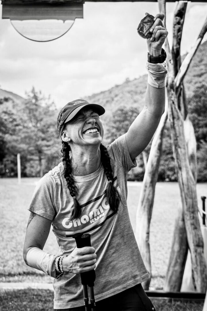 Happy woman with braids holding medal